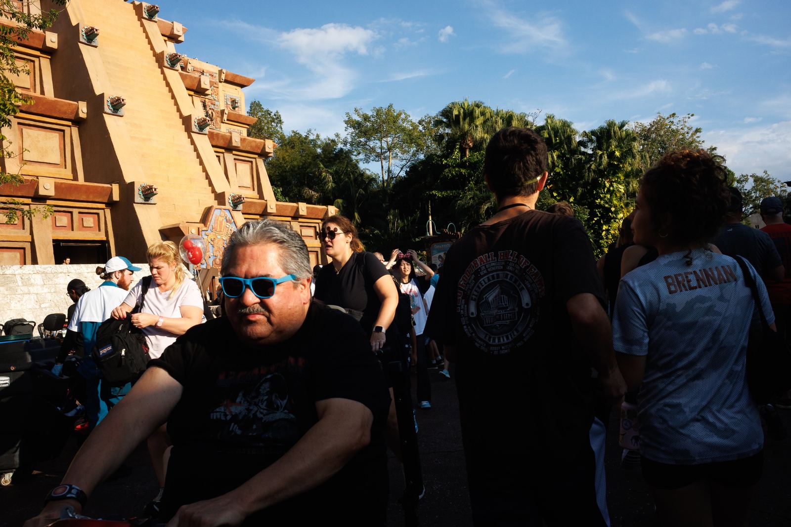 A crowded walkway split by hard afternoon light