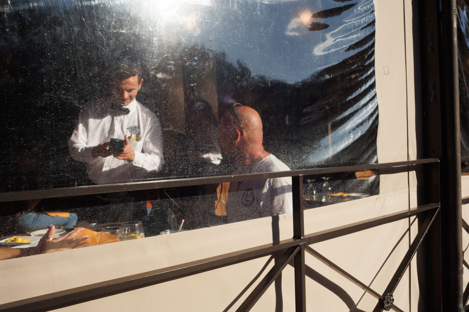 People seen through a sunlit restaurant window