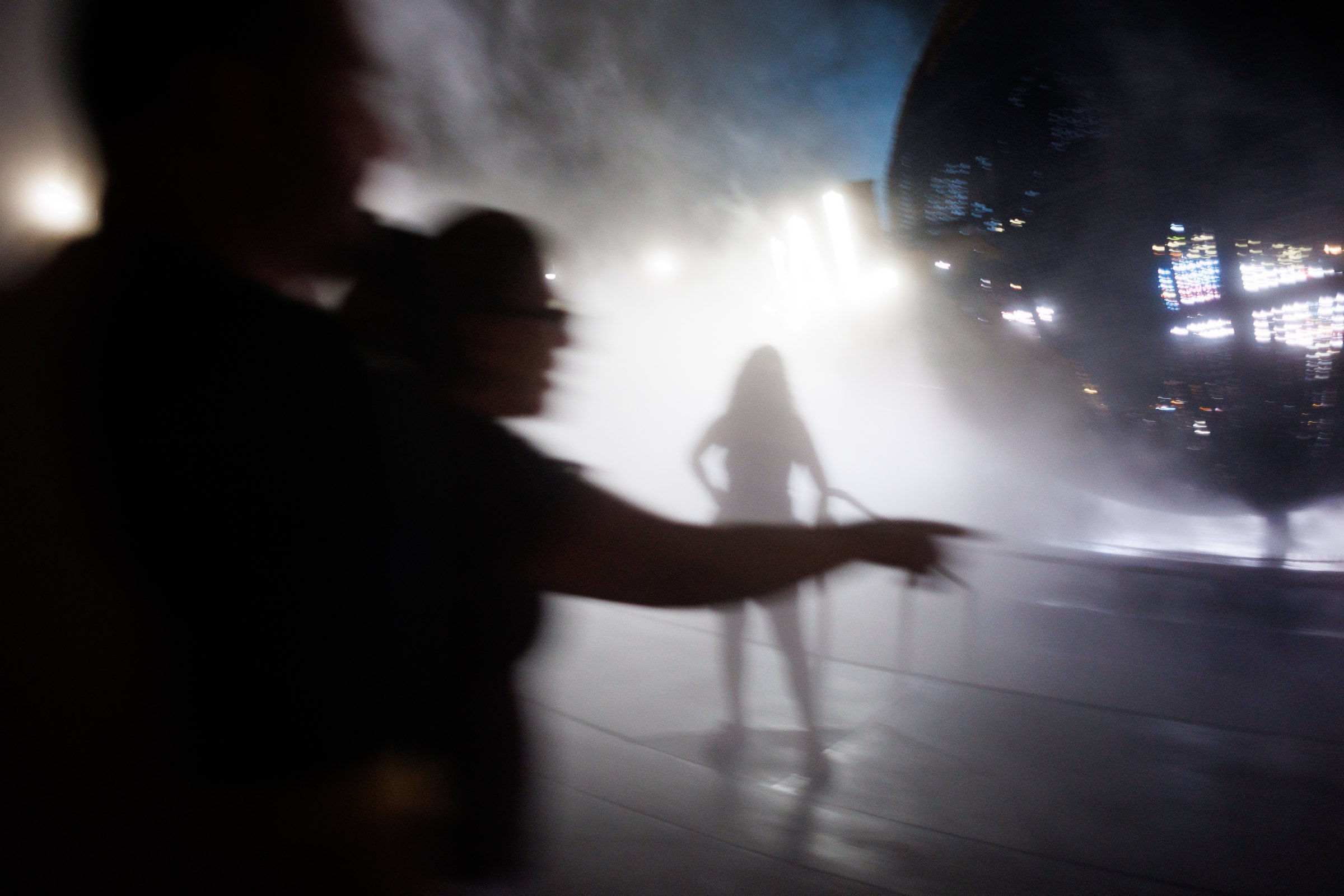 Figures moving through white light and mist